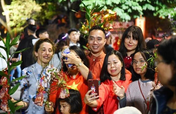 越南河内除夕晚上到处都是守岁的人,大家都会手持象征财富绿树枝。