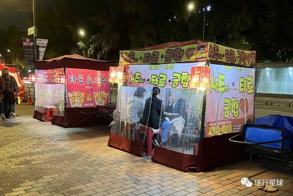 韩国大学附近的算命小棚子,上面写的分别是八字、批姻缘、塔罗。
