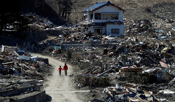 FILE PHOTO: People walk at an area that was damaged by the March 11 earthquake and tsunami, in Miyako, Iwate prefecture, April 5, 2011. REUTERS/Toru Hanai/File Photo/File Photo